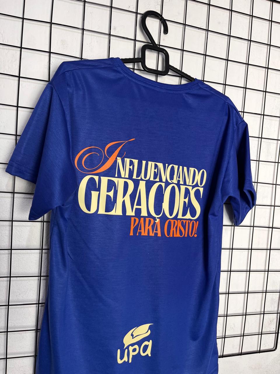 Parte de trás de camiseta azul da UPA com estampa Influenciando Gerações para Cristo