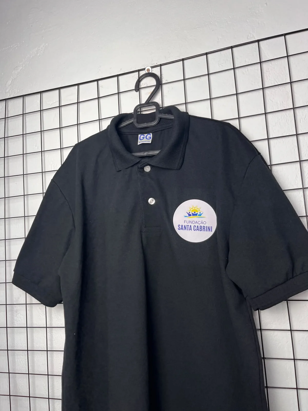 Camisa polo preta Fundação Santa Cabrini personalizada no peito